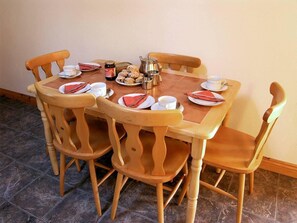 A dining table with chairs, plates, cups, and a teapot. - 2 Bed in Glengariff (oc-ii03911) (Ardnatrush Beg)