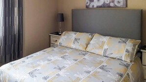 A bed with floral bedding, a bedside lamp, and a wall-mounted artwork. - 2 Bed in Castlemaine (oc-ii08066) (Aughills)
