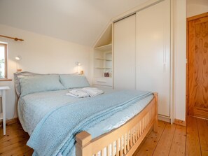 A bedroom with a bed, bedside tables, a wardrobe, and a window. - 3 Bed in Tramore (oc-ii11304) (Tramore)