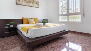Een moderne slaapkamer met een bed, nachtkastjes, een raam en een decoratief wandobject.