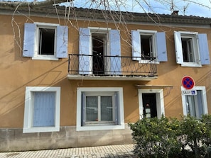 A building with multiple windows, a balcony, and a no parking sign. - Spacious house in centre of Quillan (Quillan)