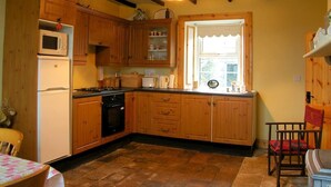 Une cuisine avec des meubles en bois, un four à micro-ondes et une cuisinière.