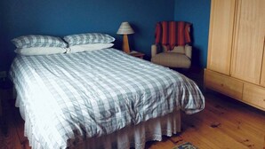 A bedroom with a bed, a chair, a lamp, and a wardrobe. - 4 Bed in Dunquin (oc-ii08697) (Dunquin)