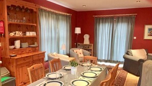A dining area with a table set for four, surrounded by wooden chairs. - 4 Bed in Dunquin (oc-ii08697) (Dunquin)