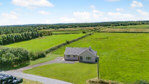 Une maison de plain-pied avec un toit en pente, une allée pavée et une pelouse bien entretenue.