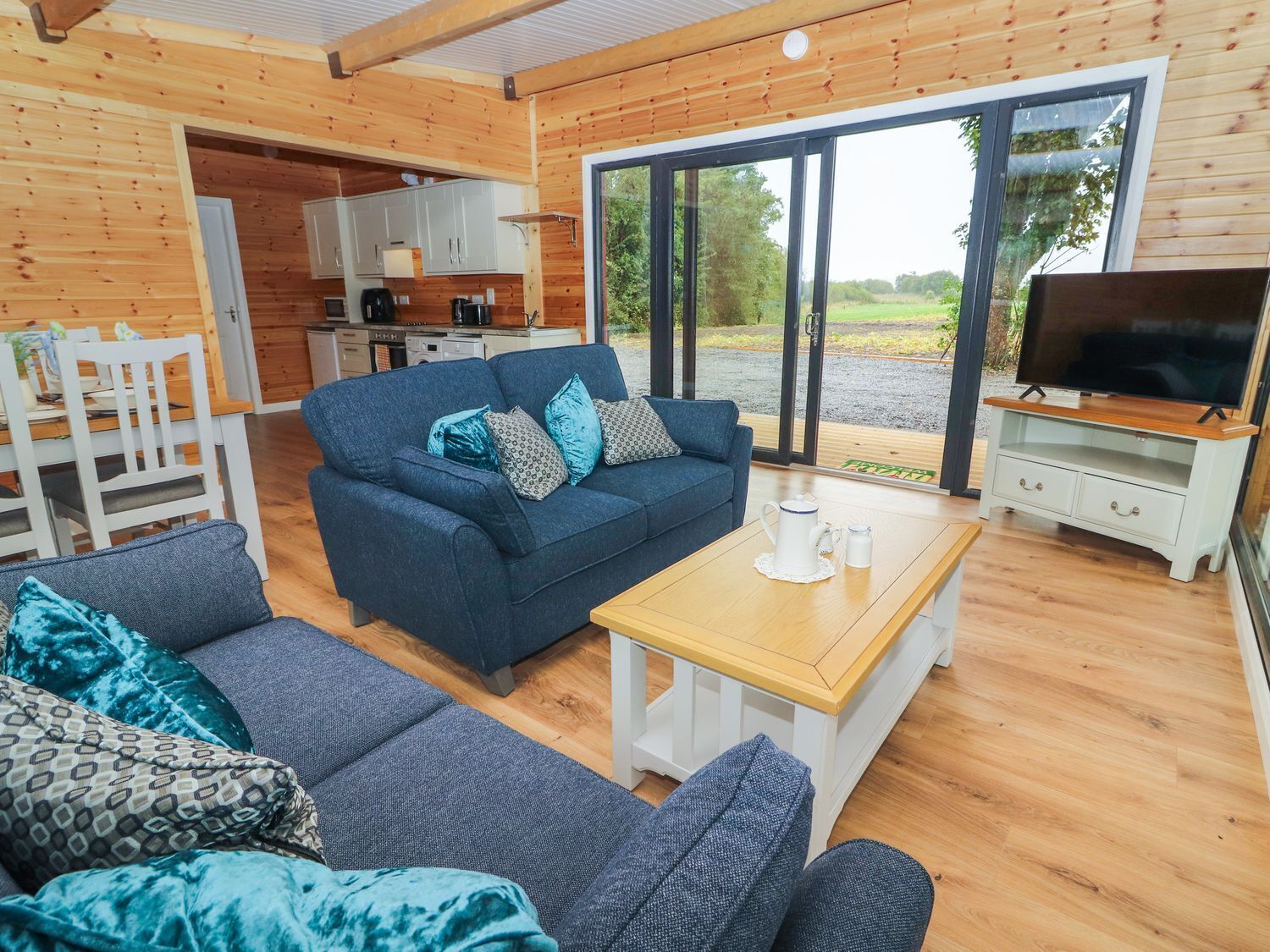 Un intérieur de chalet chaleureux avec un canapé, une table basse et un coin télévision.