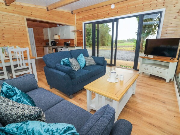 A cozy cabin interior with a sofa, a coffee table, and a TV area.