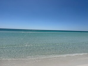 Una playa con agua cristalina y cielo despejado.