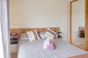 A neatly made bed with striped pillows, a bedside lamp, and a rolled towel on the bed. - 3 Bed in Moville (oc-ii07029) (Moville)