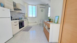 Eine moderne Küche mit integriertem Backofen, einem Gasherd und einer Spüle. Es gibt einen Essbereich mit Tisch und Stühlen.