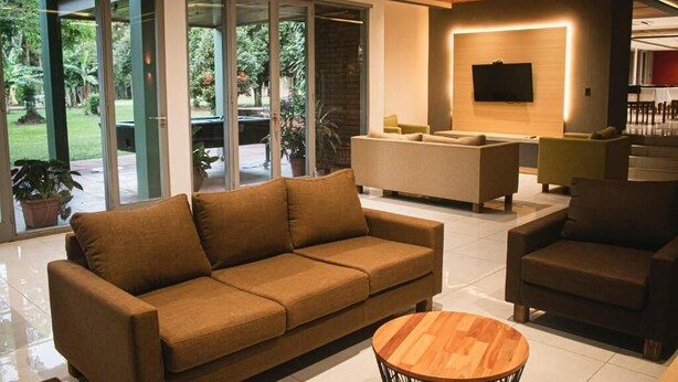 A modern living room with a sofa, armchair, and a round coffee table.