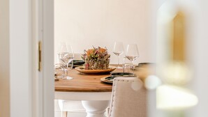 Une table à manger agrémentée d’un centre de table, de verres à vin et d’assiettes.