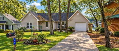 A residential area with two houses, a driveway, and a mailbox.