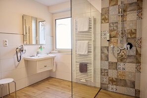 Superior driepersoonskamer | Badkamer | Een douche, een haardroger, handdoeken