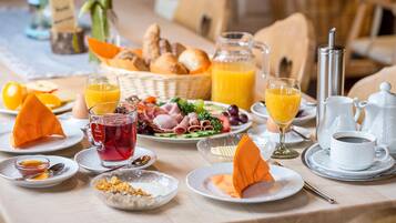 A breakfast setting with various food items, drinks, and dining utensils.
