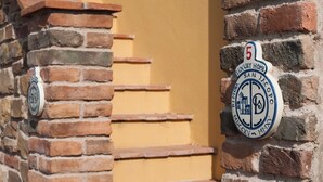Eine Ziegelwand mit einem Schild, das 'Luxury Home San Jacopo' und die Nummer 5 zeigt.