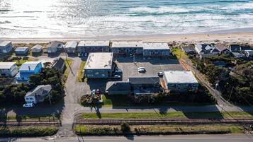 Luchtbeeld van een kustgebied met een parkeerplaats, gebouwen en een strand.
