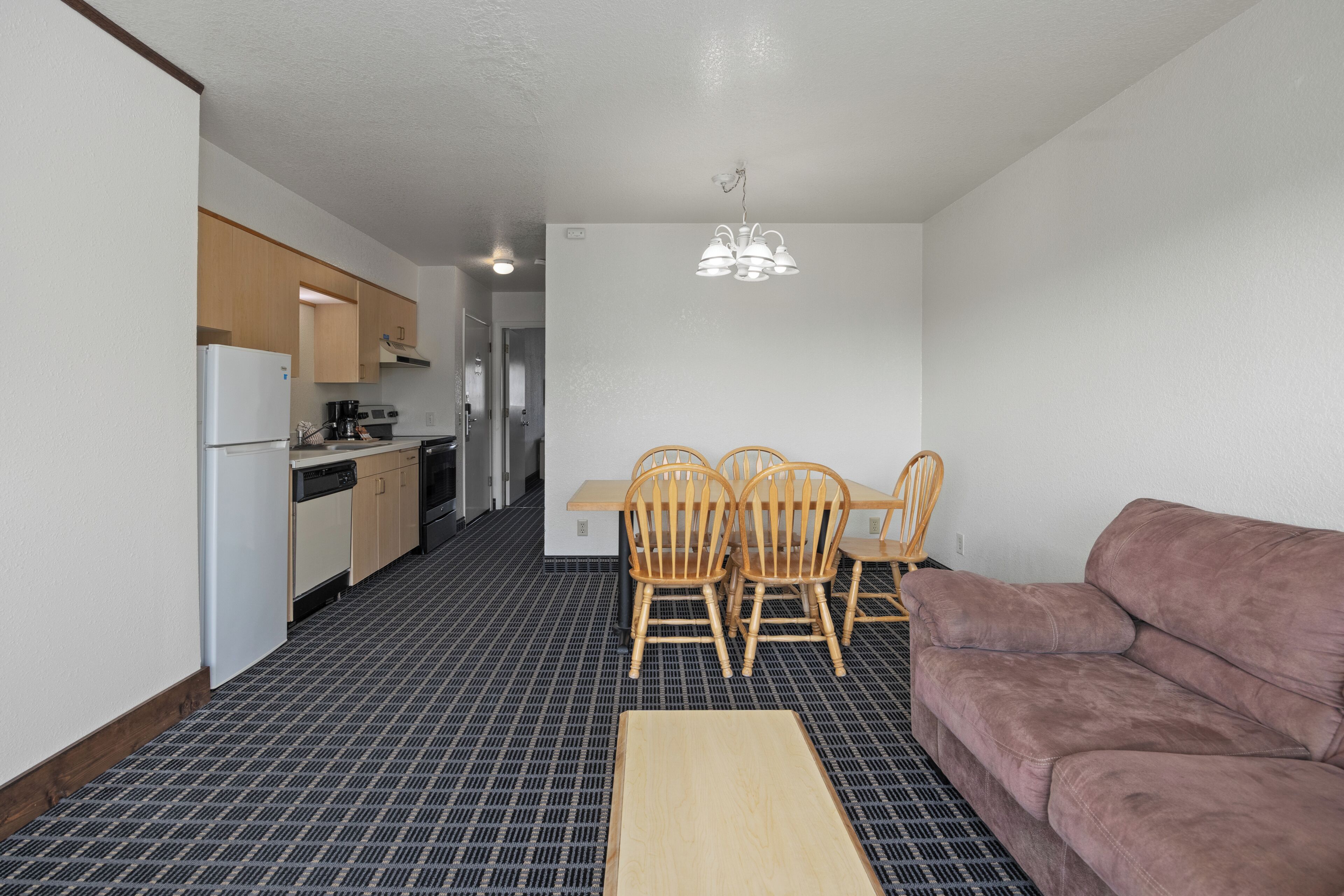 Een ruimtelijke leefruimte met kitchenette, eethoek en zitgedeelte.