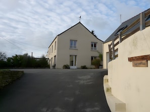 Un bâtiment à deux étages, doté d’un toit en pente, d’une antenne parabolique et d’une enseigne sur laquelle on peut lire « Bienvenue ».