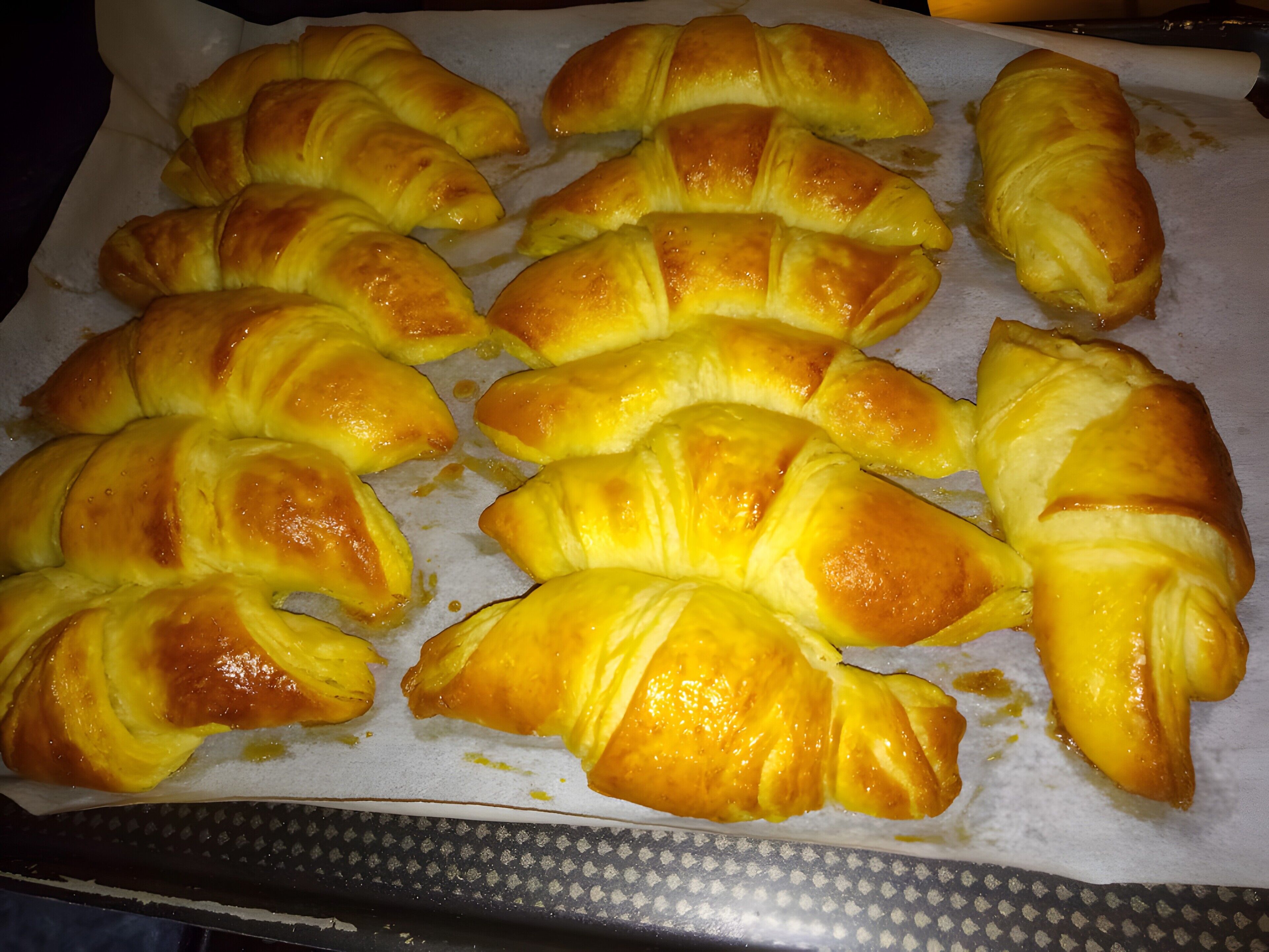 A tray of golden-brown pastries arranged on parchment paper.