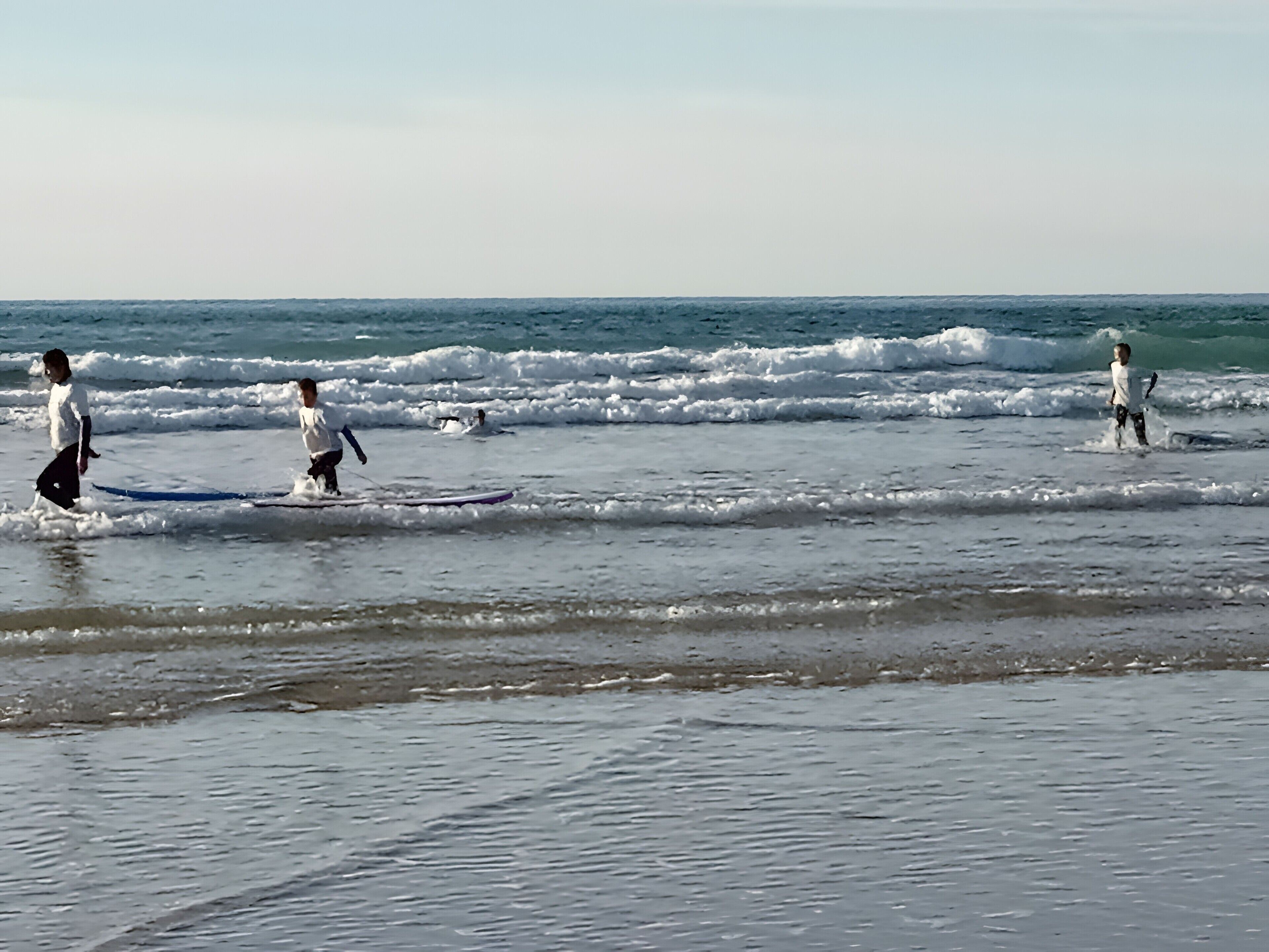 Ein Strand mit Surfern und Wellen.