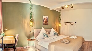 Une chambre à coucher comprenant un lit, une table de chevet, une chaise et un luminaire fixé au mur.