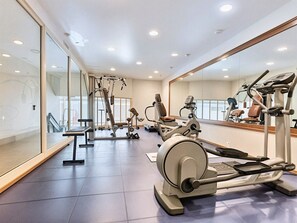 A gym with various exercise equipment, including treadmills and weight machines, and a large mirror on one wall. - 14494222 FRGK OXFORD Palace Park (Cannes)