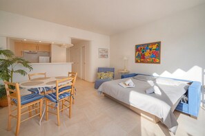 Ein modernes Hotelzimmer mit einem Bett, einem Schreibtisch und einem Essbereich.
