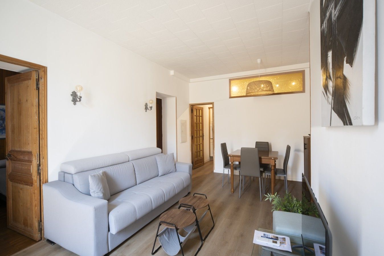 Una sala moderna con sofá, mesa de comedor, sillas y una mesita auxiliar.