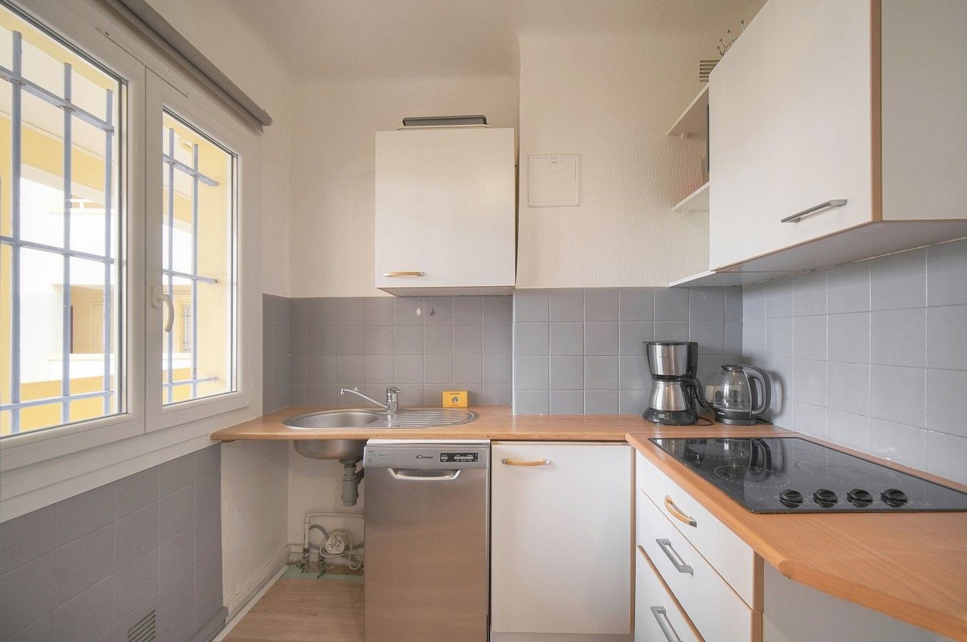 A compact kitchen with a sink, stove, and dishwasher.