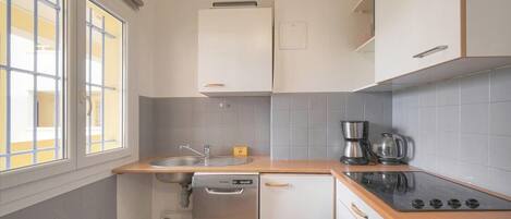 A compact kitchen with a sink, stove, and dishwasher.