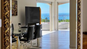 A modern room with a glass table, black chairs, a painting, and a view of the sea. - FRGK Dream Villa with Sea View Overlooking Cap d (Vallauris)