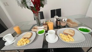 A breakfast table with plates of scrambled eggs, toast, and a glass of orange juice. - Hotel Arupo Residence Aeropuerto (Tababela)