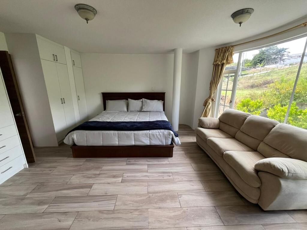 Un dormitorio con cama, sofá y armario.