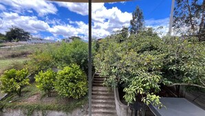 A view from a window overlooking a garden with a staircase leading to a covered area. - Hotel Arupo Residence Aeropuerto (Tababela)