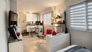 A compact living space with a kitchenette, a dining area, a workspace, and a bed. - SURCOUF (Cannes)