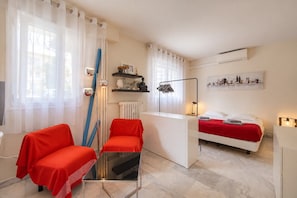 Ein Hotelzimmer mit Bett, Schreibtisch, Stuhl und einem kleinen Tisch.