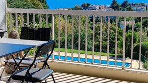 A balcony with a view of a swimming pool and the sea. - THE HORIZONS (Cannes)