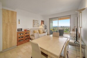 Eine moderne Wohnung mit Essbereich, Küche und einem Balkon mit Blick auf die Stadt.