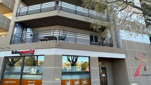 Un edificio de varios pisos con balcones, un escaparate con la etiqueta 'Intermarché Express' y un letrero que indica 'Entrada a 15 m'.