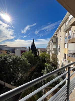 Un edificio residenziale con balconi, cielo sereno e vegetazione circostante.
