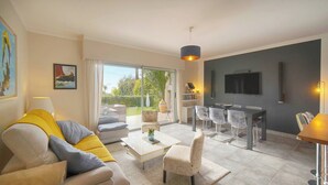 A modern living room with a sofa, coffee table, and dining area. - FRGK Diane Elegance and Comfort in Antibes (Antibes)