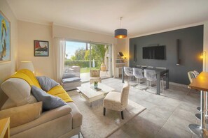 Ein modernes Wohnzimmer mit Sofa, Couchtisch und Essbereich.