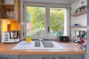 Una cocina con un lavamanos doble, una cafetera y un tostador.