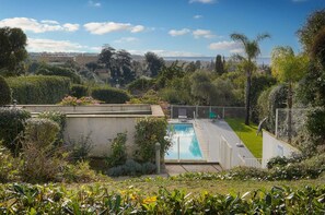 A residential area with a swimming pool, surrounded by greenery and a view of a distant cityscape. - Frgk *Diane | Elegance and Comfort in Antibes* (Antibes)