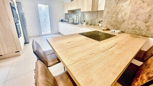 Una cocina moderna con una isla central, armarios de madera y un ventanal amplio.