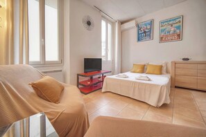 Ein Hotelzimmer mit Bett, Fernseher, Schreibtisch und Fenster.