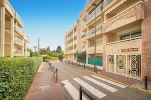 A street view of a residential area with apartment buildings, a pedestrian crossing, and a café named 'CANNES MELODIE'. - Frgk - Gallieni: A Quiet Studio (Cannes)