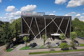 Un bĂątiment moderne dotĂ© dâune façade en verre et dâun parking.