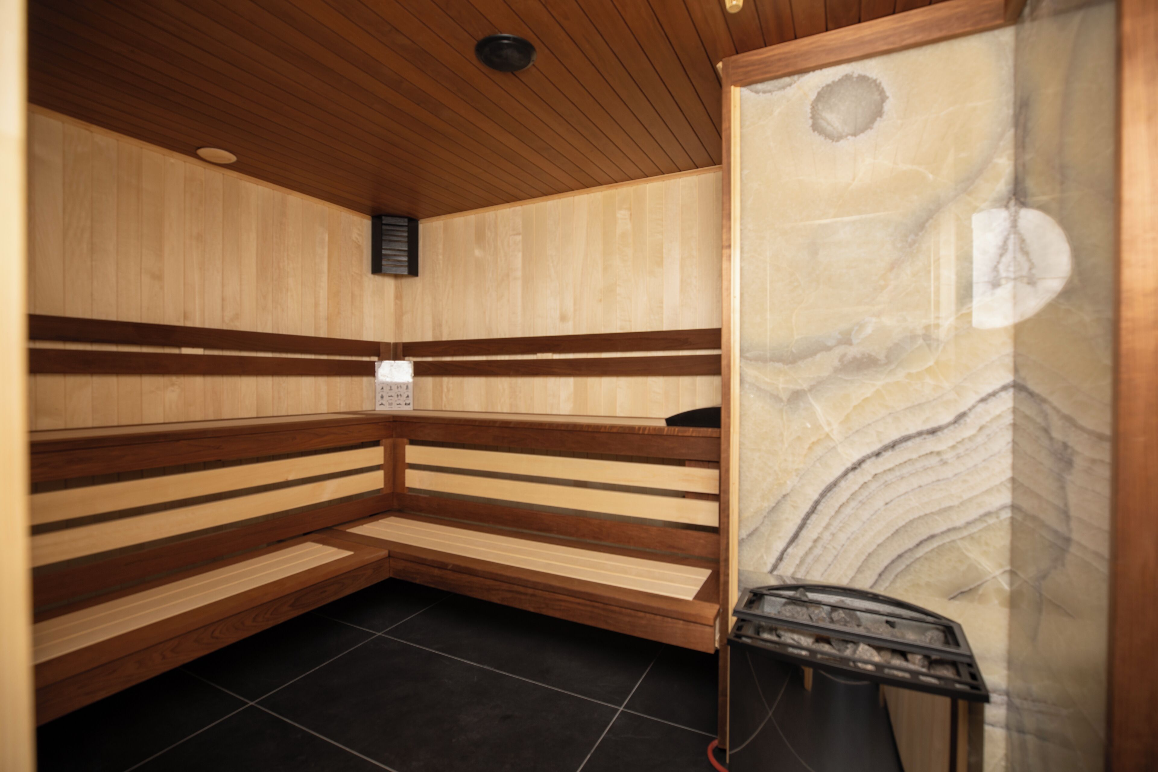A sauna with wooden benches and a tiled floor.